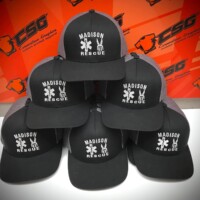 stack of black hats with an embroidered logo